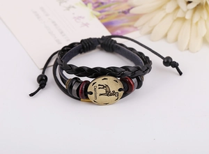 Dettaglio del ciondolo Capricorno in bronzo su un bracciale multistrato in pelle nera