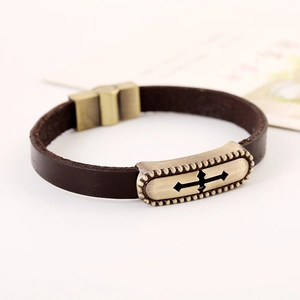 Leather bracelet with cross pendant and vintage alloy charm on white background