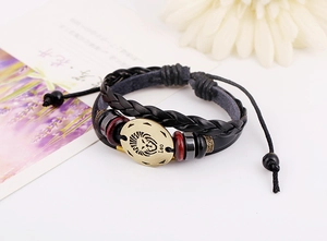 Detail of handmade leather Leo zodiac bracelet with bronze charm and beaded accents