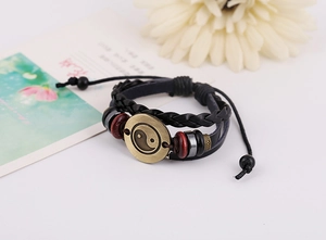 Detail of multi-layer leather bracelet with bronze Yin Yang charm and wooden beads
