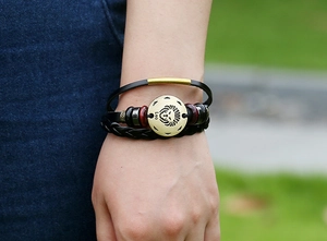 Close-up of handmade multilayer leather bracelet with golden Leo zodiac sign and beads