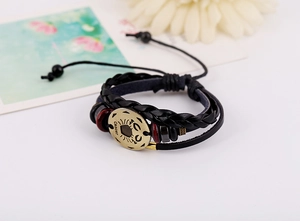 Macro view of Cancer zodiac leather bracelet with antique gold charm and beads