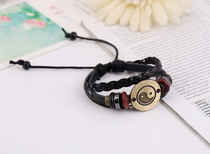Detail of layered leather bracelet with bronze Tai Chi Yin Yang charm and beads