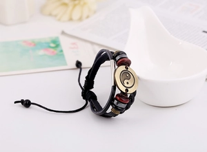 Detail of vintage multilayer leather bracelet featuring bronze Yin Yang charm and beads