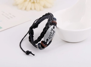Detail of multi-layer leather bracelet with LOVE engraving and wooden beads