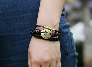 Close-up of handmade multi-layer leather Aquarius zodiac bracelet with vintage wooden beads