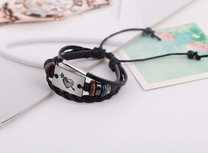 Détail du bracelet en cuir punk avec plaque en métal cœur vintage et perles de bois