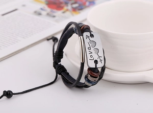 Detail of layered leather bracelet with silver Love plaque and colorful beads