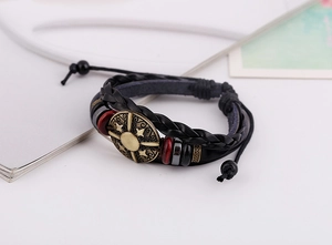 Detail of layered leather bracelet with bronze sunburst disc and adjustable cord