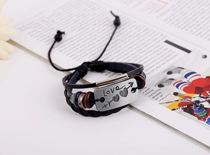 Detail of multi-layer leather bracelet with Love engraved metal plate and wooden beads
