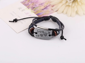 Macro detail of multi-layer leather bracelet with silver Love heart plaque and wood beads