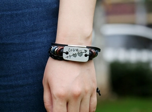 Detail of multi-layer leather bracelet with engraved Love metal plate and beads