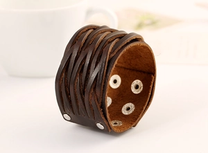 Détail du bracelet en cuir tressé marron foncé avec bouton pression argenté sur table