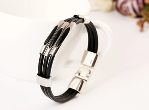 Macro detail of a triple-strand black leather bracelet on a white ceramic cup