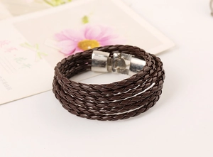 Detailed view of dark brown braided leather bracelet with silver metal clasp