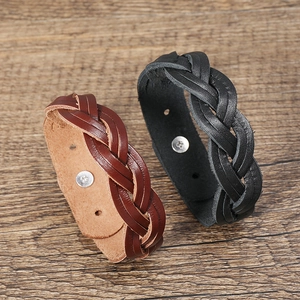 Detail of hand-woven vintage leather bracelets in black and brown with metal snap buttons