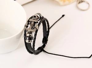 Detail of a men's vintage anchor leather bracelet with multi-layer braided punk style