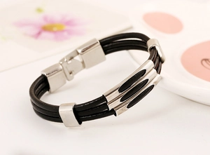 Detailed close-up of a triple-strand black braided leather bracelet with silver metal tubes