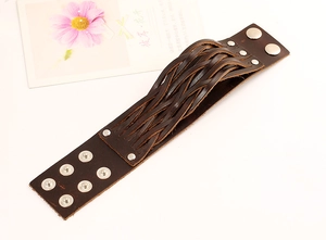 Détail d'un bracelet en cuir tressé marron foncé avec boutons-pression réglables en métal