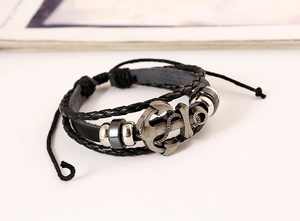 Macro shot of retro leather multi-layer bracelet with vintage silver anchor pendant detail