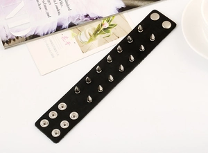 Detail of a punk leather bracelet with double-row silver metal studs and snap buttons