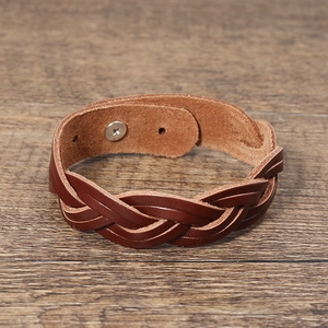 Detailed view of woven brown leather bracelet with silver adjustable metal snap button