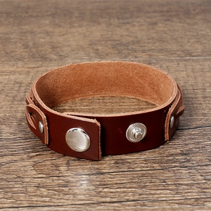 Detail of dark brown multi-layer leather bracelet with silver metal snap buttons