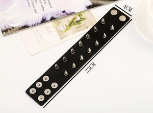 Macro shot of punk black leather wristband with 14 silver metal spikes and snap buttons