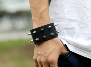 Close-up of black leather punk bracelet featuring silver metal cone rivets and studs