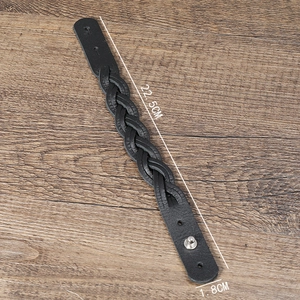 Minimalist black braided leather bracelet with silver buckle on a wooden background