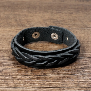 Detail of multi-layer black braided leather bracelet with vintage silver snap buttons