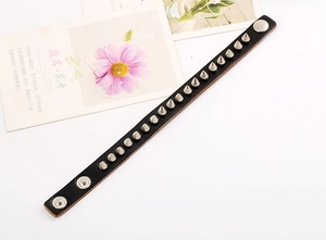 Close-up of black leather punk bracelet with silver metal spikes and snap button clasp