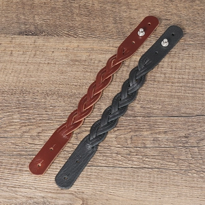 Detail of hand-woven leather bracelets in black and brown with silver metal studs