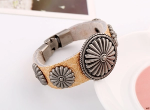 Détail d'un bracelet en cuir craquelé vintage avec des clous métalliques gravés