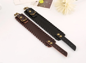 Detail view of punk style leather bracelets in black and brown with woven edges