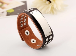 Macro shot of punk style brown leather bracelet with silver rivets and metal plate detail