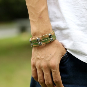 Retro double-wrap leather bracelet with silver skull rivets in a green-gold vintage finish
