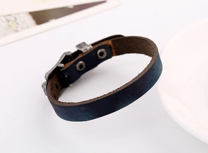 Macro detail of retro punk leather bracelet with vintage metal buckles and navy blue texture