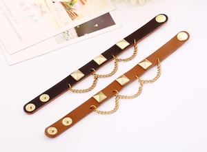 Close-up of leather punk bracelets with gold pyramid studs and adjustable snap buttons
