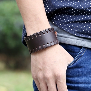 Vintage wide dark brown leather woven bracelet for men styled with a blue casual shirt