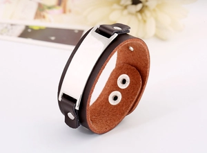 Gros plan sur un bracelet en cuir marron avec plaque argentée polie et boutons pression