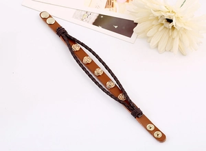 Detail of vintage leather bracelet featuring golden rose studs and adjustable snap buttons