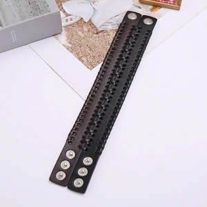 Detail von geflochtenen Punk-Lederarmbändern in Schwarz und Braun mit silbernen Druckknöpfen