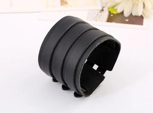Close-up of a wide black multilayer genuine leather bracelet with punk rock matte texture