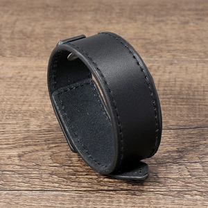 Detail of black leather bracelet with fine stitching and metal snap button closure