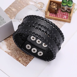 Detail eines breiten schwarzen Lederarmbands mit Kreuzstich und Druckknöpfen aus Metall