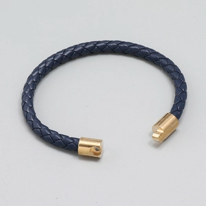 Men's navy blue braided leather bracelet with a gold metal clasp shown on flat surface
