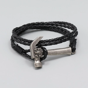 Detailed macro of a braided black leather bracelet with a vintage silver skull hammer clasp