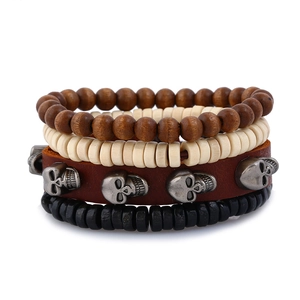 Détail d'un bracelet multicouche en cuir avec perles en bois et breloques de crâne