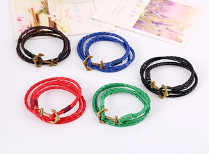 Detail of multi-color braided leather bracelets featuring vintage bronze anchor clasps
